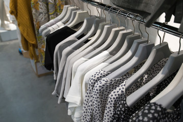 Fototapeta premium Clothes hang on a shelf in store