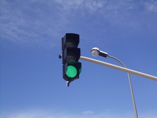 Gr&uuml;ne Ampel mit Stra&szlig;enlaterne im Hintergrund 