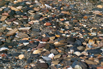 Pebbles under water background. Shallow depth of field. Focus on the center.