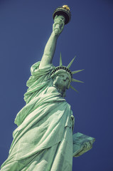 Fototapeta premium Statue of Liberty in front of blue sky, Liberty Island, New York City, USA, vintage filtered style
