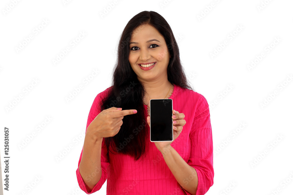 Wall mural happy young woman holding mobile photne against whtie background