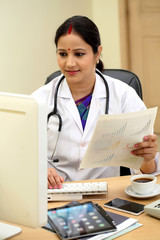 Young female doctor checking patient documents