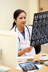 Tradtional Indian female doctor examing MRI scan report - 125032204