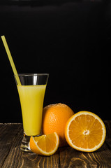 glass of juice, orange on a black background