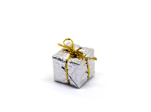 Small white gift on white background. Christmas gift box in foliage wrapping with gold thread bow.