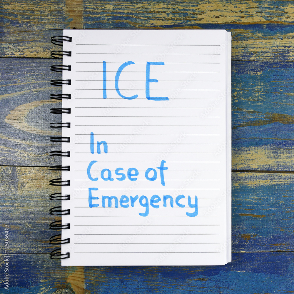 Poster ice- in case of emergency text written in notebook on wooden background
