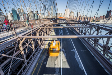 Obraz premium Taxi taksówka krzyżuje most brooklyńskiego w Nowy Jork, Manhattan linia horyzontu w tle