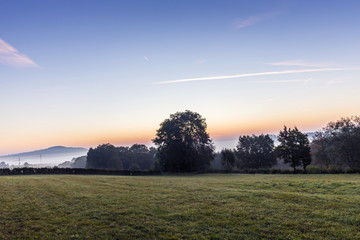 Obraz na płótnie Canvas sunrise in german countryside with hills in the Eifel