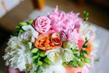 Wedding rings with bouquet of peonies
