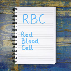 RBC- Red Blood Cell acronym written in notebook on wooden background