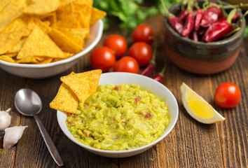 Guacamole in home white on wooden desk.