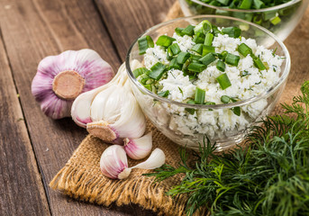 Homemade Herb Curd in bowl (close-up shot) on vintage wooden bac