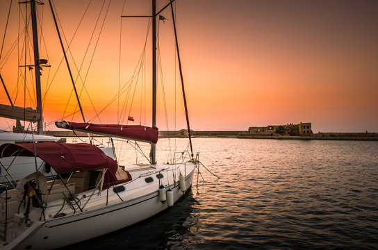 Boats in old venetian  port of Chania at sunset. View of the old venetian harbor of Chania on Crete island, Greece.