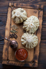 Serving tray with khinkali dumplings, satsebeli sauce and pepper