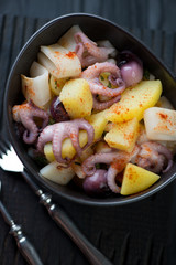 Closeup of octopus and calamari salad with potato and parsley