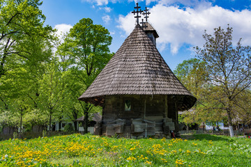 Small wooden old church in field.