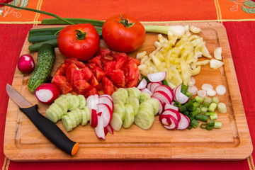 Wooden cutting board with vegetables.