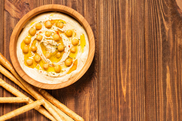 Hummus on a wooden background, soft focus, horizontal, top view, close-up