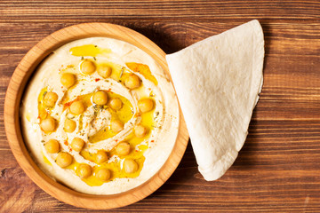 Hummus on a wooden background, soft focus, horizontal, top view, close-up