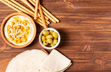 Hummus on a wooden background, soft focus, horizontal, top view