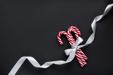 Christmas candy with silver ribbon on black background. Christmas background. Top view and copy space. Christmas concept.
