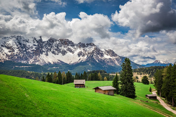 Fototapeta na wymiar Small valley with cottages in spring, Dolomites, Italy