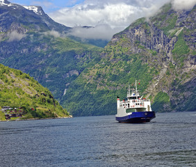 Small passenger ferry departing the village of Geiranger in the headwaters of the beautiful Geiranger Fiord in Norway