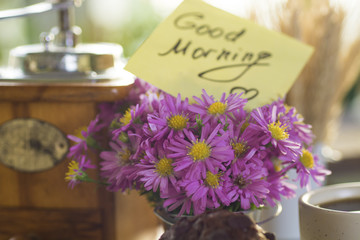 sunny morning breakfast - cup of coffee with bouquet of flowers and and chocolate brownies, wheat sheaf in a decorative bucket. note text good morning, soft focus insta filter image. 