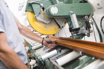 Manual worker cutting aluminum and PVC profiles. Manufacturing jobs. Selective focus. Factory for aluminum and PVC windows and doors production.