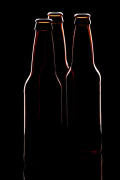 Silhouette of three brown beer bottles