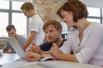 Obraz premium kollegen unterhalten sich am schreibtisch