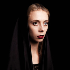 Portrait of sad girl in mourning dress on black background