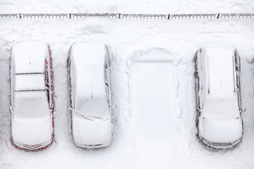 Covering with snow line of vehicles with vacant parking place, snowfall at winter