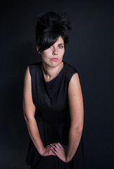 photo woman in a black dress with a high hair leans on his hands