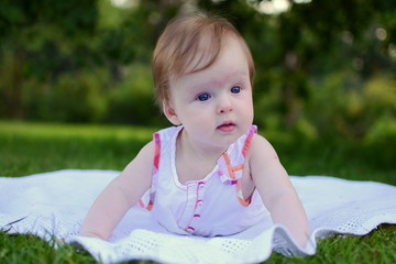 Little baby girl lying in the grass