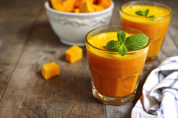Two portions of fresh pumpkin juice with mint leaf in a glasses.