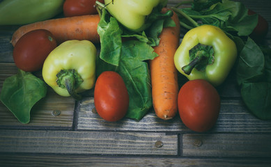 vegetables on a wooden background, carrots, peppers, tomatoes an