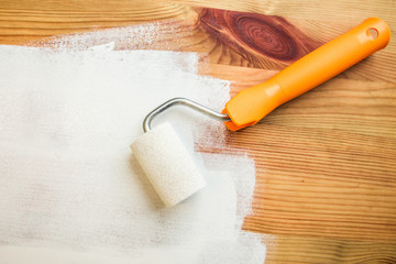 Ein Holztisch wird mit weißer Farbe lackiert