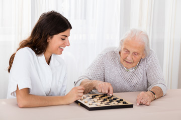 Two Women Playing Checkers Game