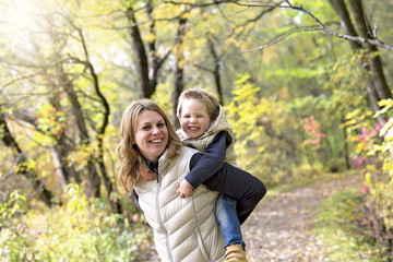 Fototapeta premium Adorable little boy with his mother in autumn park