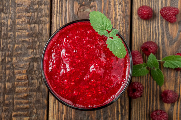 Smoothie with raspberry and mint on dark wood table. Top view