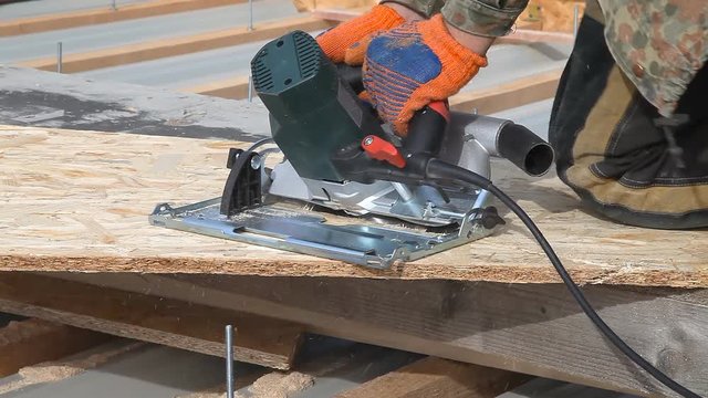 Sawing wood board powerful electric saw / Sawing wood board powerful electric saw. Worker does cut a wide wood board