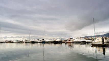 Fototapeta na wymiar Reflejos en el puerto de Rosas en un día nublado