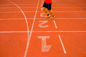 The legs of the men came jogging on a running track to cross the finish line.