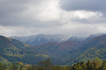 Fototapeta premium Sun breaking through on a snowy mountain top