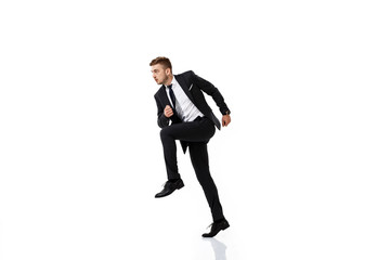 Young successful businessman in suit running over white background.