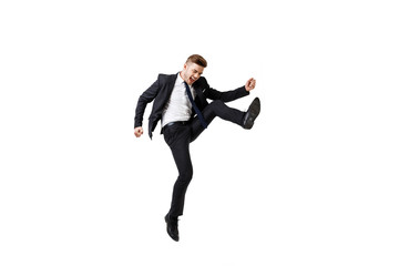 Young successful businessman in suit rejoicing, jumping over white background.