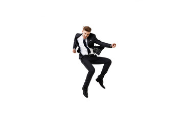 Fototapeta na wymiar Young successful businessman in suit rejoicing, jumping over white background.