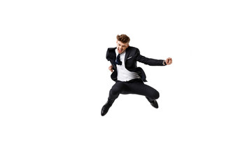 Young successful businessman in suit rejoicing, jumping over white background.