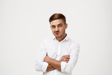 Successful businessman thinking, posing with crossed arms over white background.